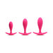 Set of three magenta silicone anal trainers in small, medium, and large sizes with curved bases for comfort.