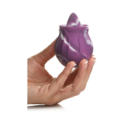 Hand holding a purple and white marbled silicone licking vibrator with a discreet power button.