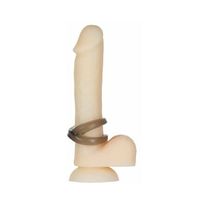Two smoky translucent cock rings displayed on a flesh-toned dildo with suction base.