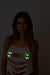 Woman wearing glowing green glitter alien pasties under a torn white top.