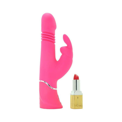 Pink dual-motor rabbit vibrator standing next to a red lipstick for size comparison on white background.