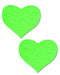 Pair of neon green heart-shaped glow in the dark adhesive pasties on white background.
