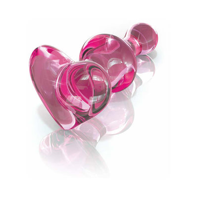 Pink hand-blown glass wand with smooth rounded shapes and a heart-shaped base on a reflective surface.