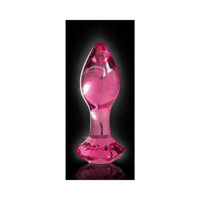 Glossy pink hand-blown glass wand with faceted base and smooth tapered tip on black background.