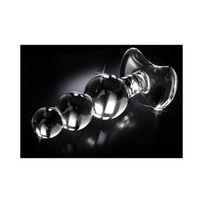Clear glass anal plug with graduated beads and a flared base on a black reflective surface