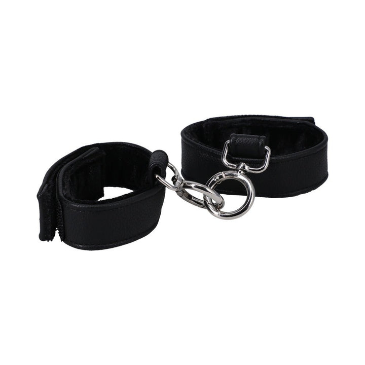 Black vegan leather handcuffs with soft velvet lining and metal connectors, adjustable with velcro closures for comfortable fit.
