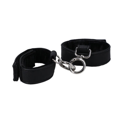 Black vegan leather handcuffs with soft velvet lining and metal connectors, adjustable with velcro closures for comfortable fit.