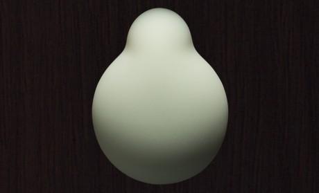 Top view of the smooth, rounded Iroha Midori massager in soft green silicone on a dark surface.