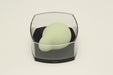 Iroha Midori green massager with smooth rounded shape displayed in clear protective case on white background.