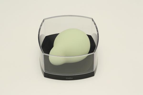 Iroha Midori green massager with smooth rounded shape displayed in clear protective case on white background.