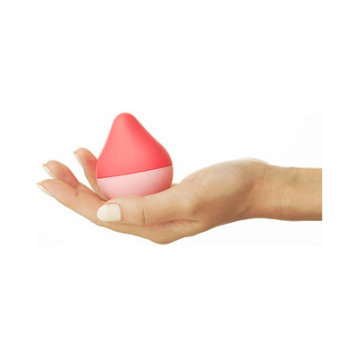 Hand holding a compact, pink and coral teardrop-shaped Iroha Mini Ume Anzu palm-sized massager.