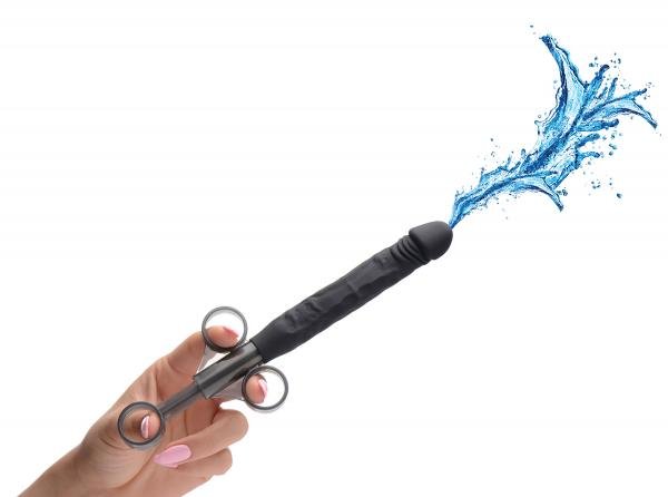 Hand holding black silicone lubricant applicator shaped like a dildo, releasing a splash of blue liquid.