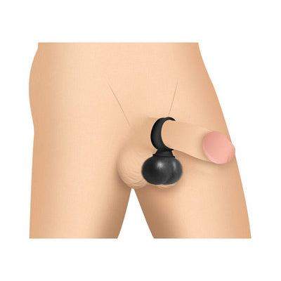Black vibrating silicone balls worn as a ring around the base of a penis on a neutral background.