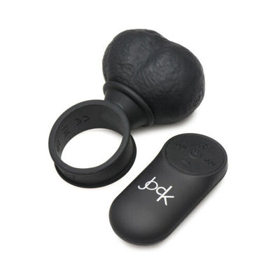 Black silicone vibrating balls with attached ring and wireless remote control on white background