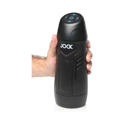 Hand holding a black Jock 9x rechargeable sucking and vibrating masturbator with control buttons on top.