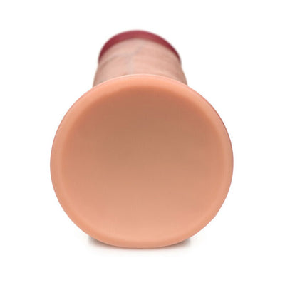 Close-up view of the suction cup base of a light-toned dual density silicone dildo.