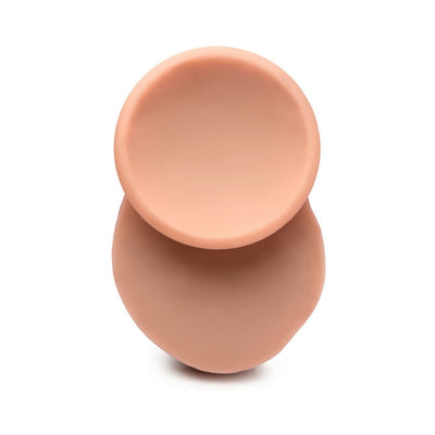 Top view of a light-colored dual density silicone dildo with attached balls and suction base on white background.