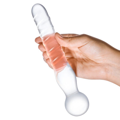 Hand holding a clear glass dildo wand with a spiraled shaft and rounded bulbous end for versatile stimulation.