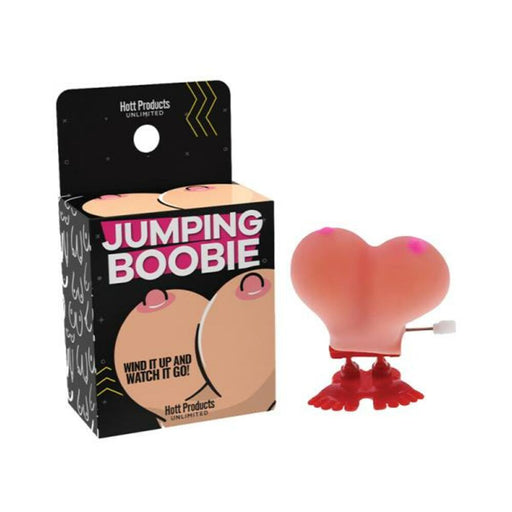 Wind-up novelty jumping toy shaped like a pair of cartoonish breasts with red feet, next to its colorful packaging.
