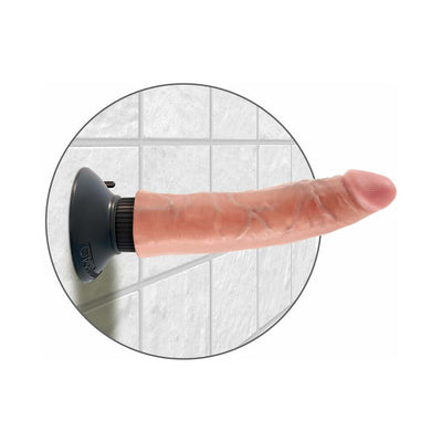 Realistic 7-inch vibrating dildo with suction cup base mounted on tiled wall for hands-free use.