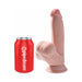 Realistic 7-inch King Cock dildo with swinging balls and suction cup base shown next to a red soda can for size comparison.