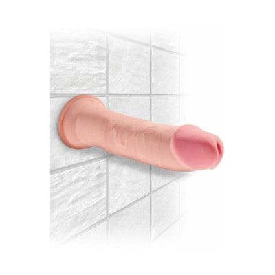Beige realistic 9-inch dildo with suction cup base mounted on white tiled wall.