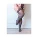 Plus size model wearing Kixies Sierra opaque grey thigh-high stockings with triple band no-slip grip.