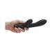 Hand holding a sleek black rechargeable silicone clitoral rabbit vibrator with ergonomic dual stimulation design.