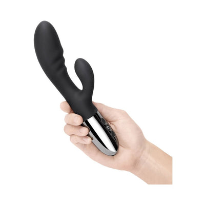 Hand holding a sleek black double-motor rabbit vibrator with a shiny silver base and control buttons.