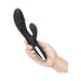 Hand holding a sleek black double-motor rabbit vibrator with a shiny silver base and control buttons.