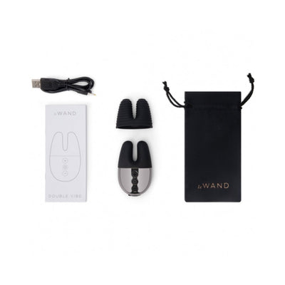 Le Wand Double Vibe with USB charging cable, textured silicone sleeve, user manual, and black drawstring travel pouch.
