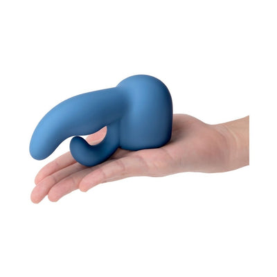 Blue silicone dual stimulator attachment resting on an open hand against a white background.