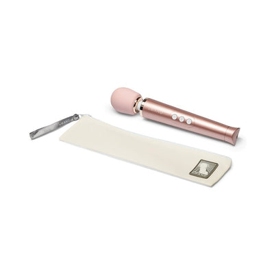 Le Wand Petite rechargeable massager in rose gold with soft silicone head and white travel pouch on white background.
