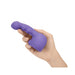 Hand holding a purple Le Wand Petite Ripple Weighted Silicone Attachment with textured, curved design.