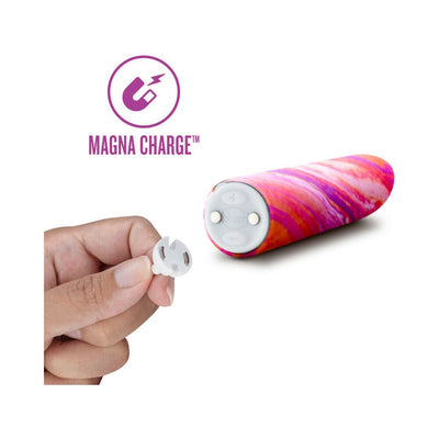 Hand holding magnetic charging adapter next to coral and pink Limited Addiction Fiery Power Vibe with visible control buttons.