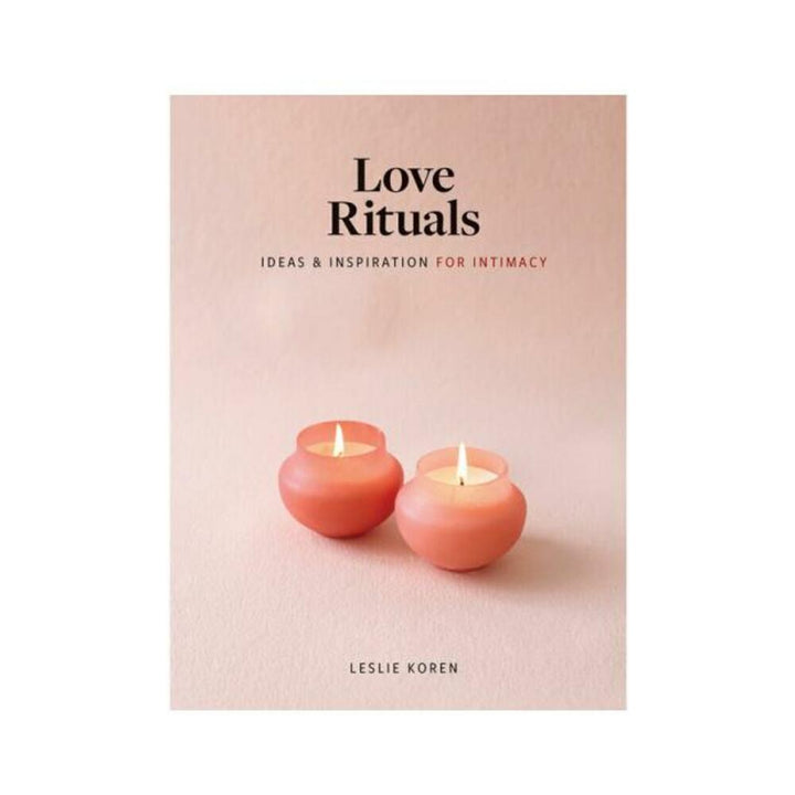 Book cover of Love Rituals by Leslie Koren featuring two lit pink candles on a soft pink background.