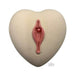 Heart-shaped beige bath bomb with a pink, stylized floral design and a small embedded pearl detail.