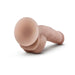 Beige realistic dildo with suction cup base lying on a white background showing detailed texture and shape.