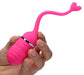 Hand holding a pink silicone rechargeable remote control egg vibrator with a heart-shaped retrieval cord.