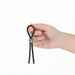 Hand holding black adjustable silicone tether with metal slider on white background