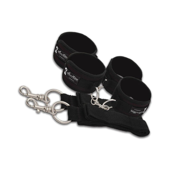 Black Lux Fetish padded wrist and ankle restraints with metal clips and adjustable straps on white background.