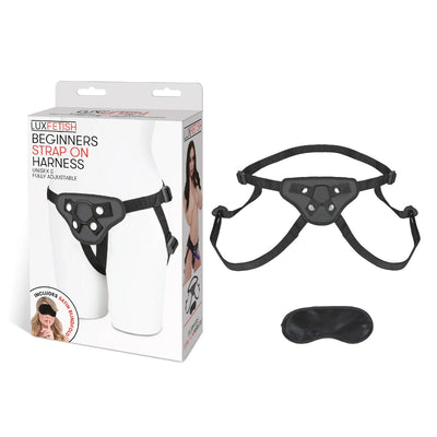 Black adjustable strap-on harness with satin blindfold and product packaging on white background.
