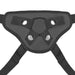 Close-up of adjustable black strap-on harness with metal snaps and O-ring for secure attachment.