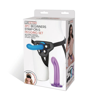 Lux Fetish Beginners Strap-on Pegging Set packaging showing adjustable harness, two curved dildos, and included satin blindfold.