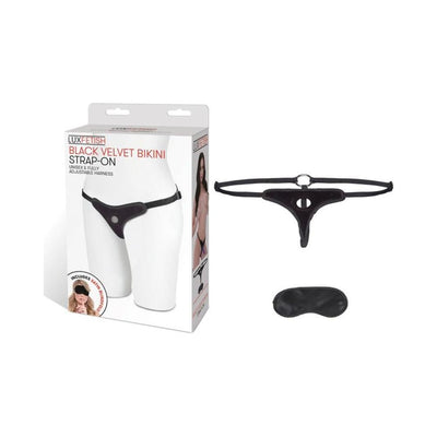 Black velvet adjustable bikini strap-on harness with satin blindfold and packaging box on white background.