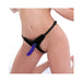 Close-up of a person wearing a black velvet bikini strap-on harness with a purple silicone dildo attached.