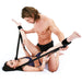 Couple using Lux Fetish Position Pal black sex sling with adjustable ankle straps on white bedding