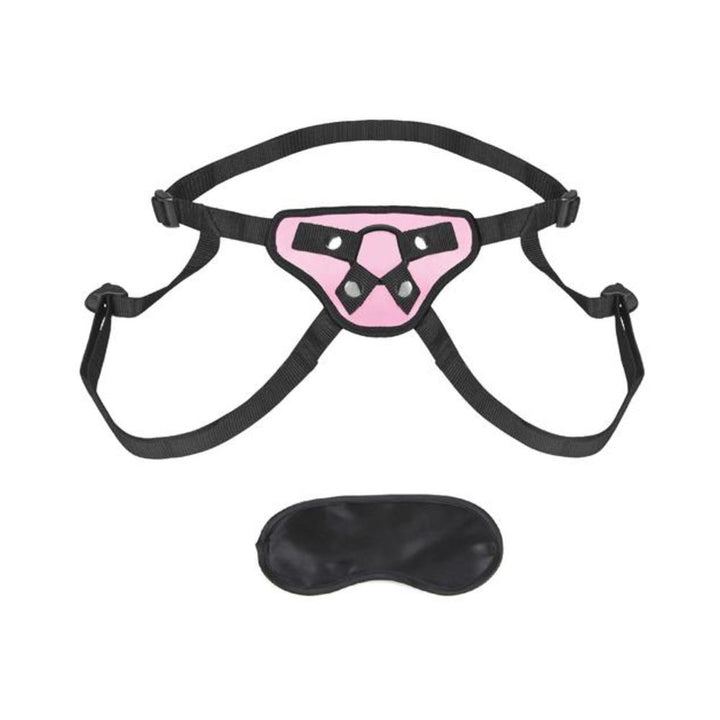 Pink and black adjustable strap-on harness with black blindfold accessory on white background