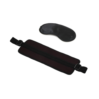 Black adjustable love cuffs with soft padding and a matching black satin blindfold on a white background.