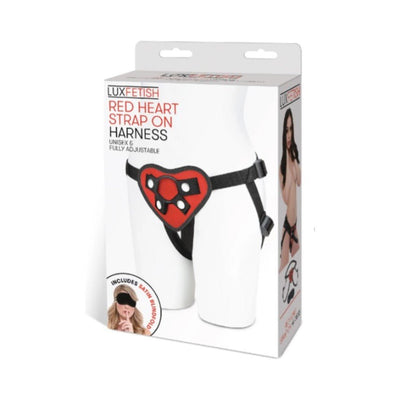 Lux Fetish red heart-shaped adjustable strap on harness displayed on white mannequin with packaging box.